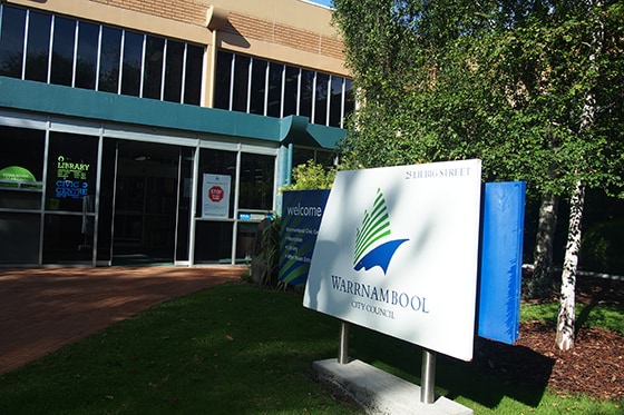 Sign in foreground with a door to a building behind it